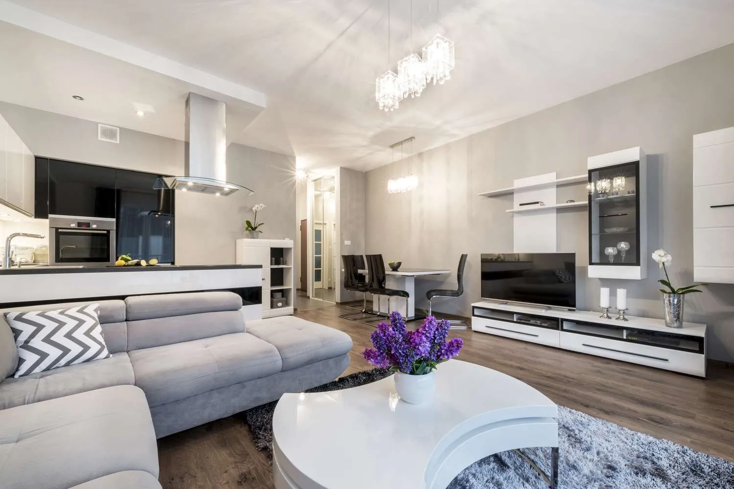 Open-plan living room with a flat-screen TV on a white media wall